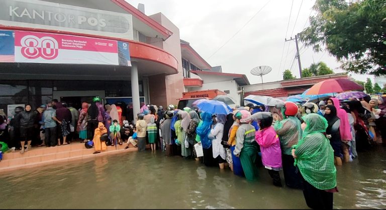 Ratusan Warga Berbalut Jas Hujan Padati Kantor Pos Lhokseumawe untuk Jemput BLTS Kesra